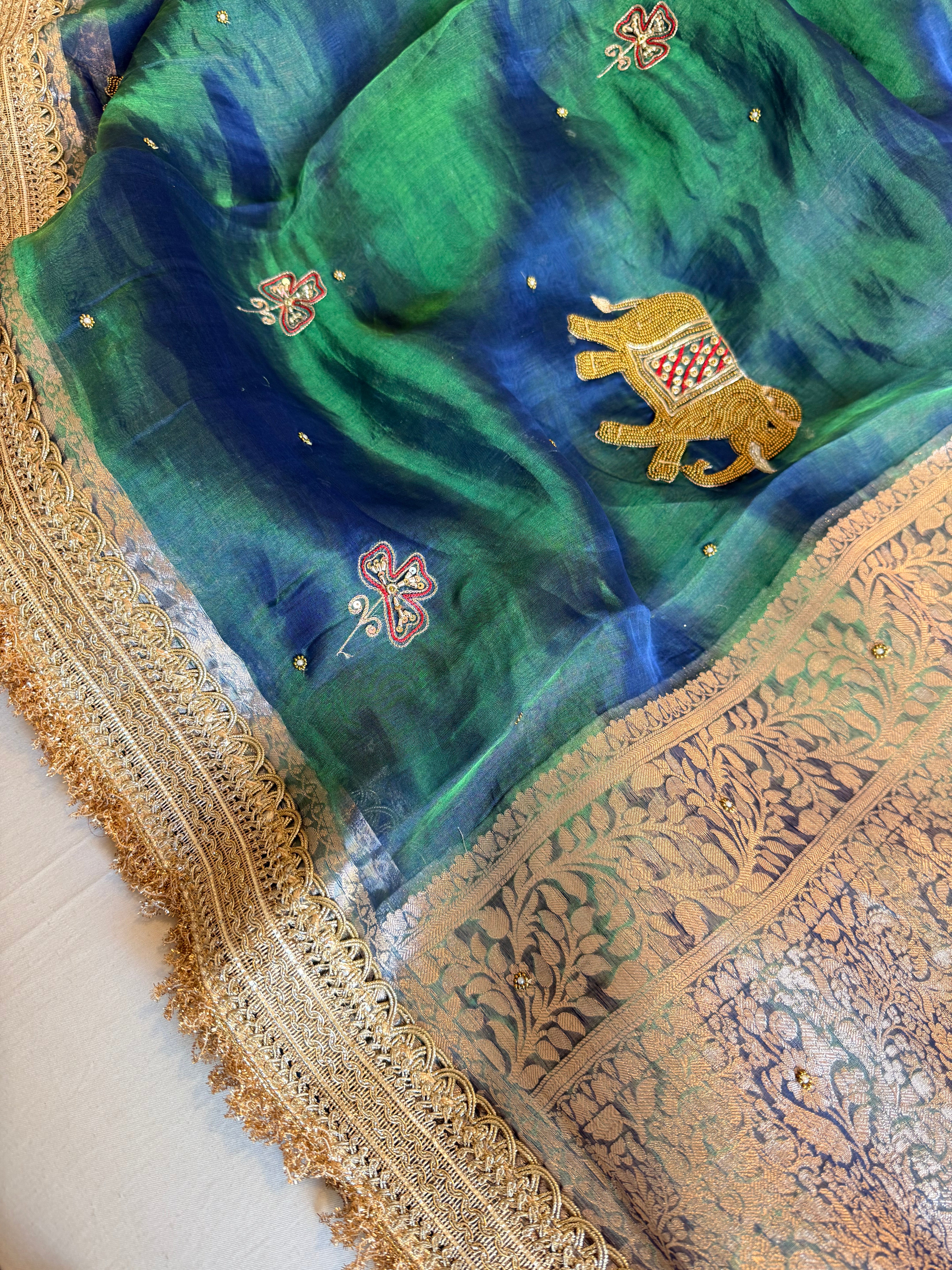 Elephant motif peacock blue dhup chao effect tissue silk hand embroidered saree