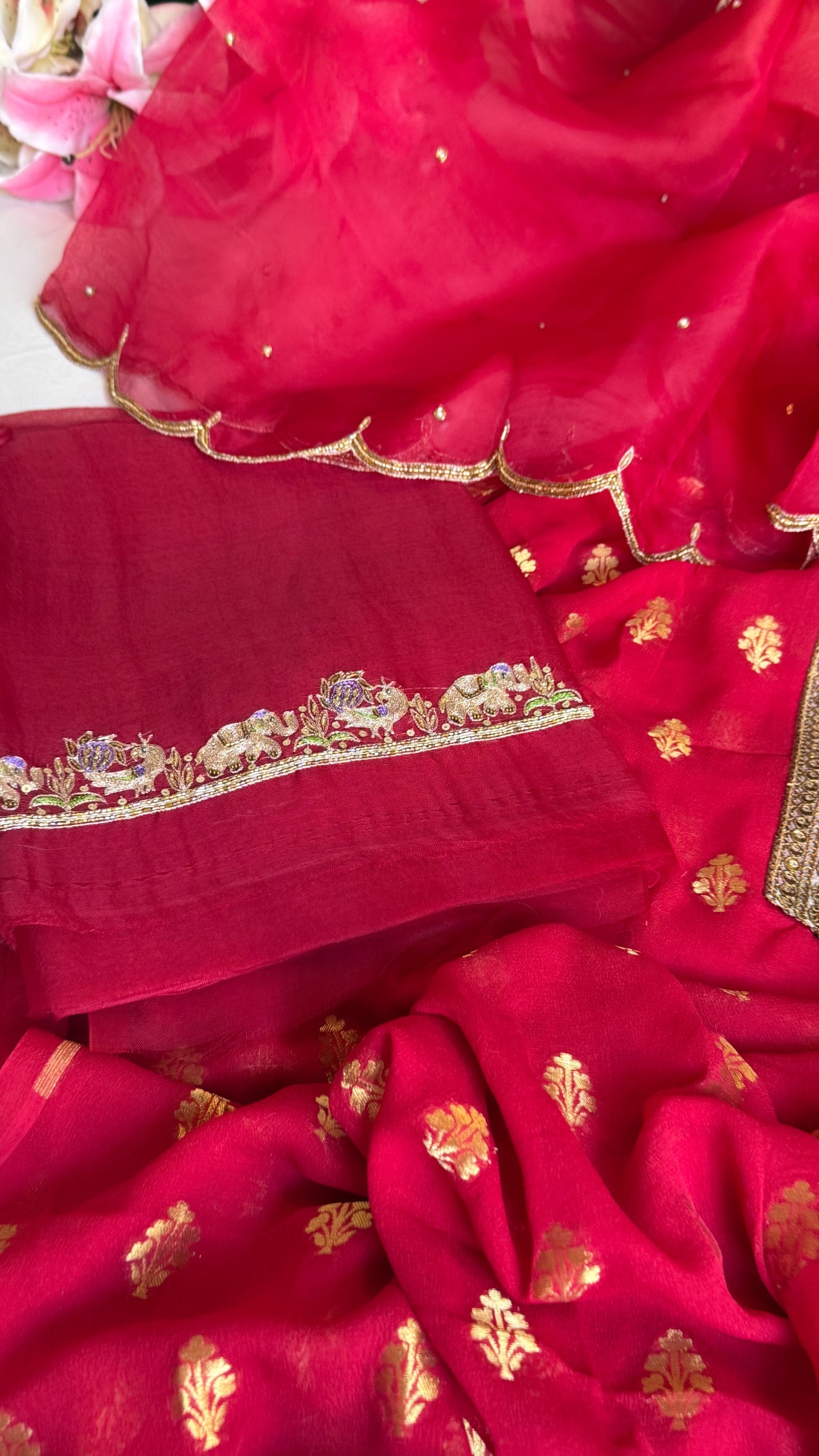 Crimson red banarasi gorgette kadhwa buti kurta paired with toy hathi motif kora silk scalloped duppata set