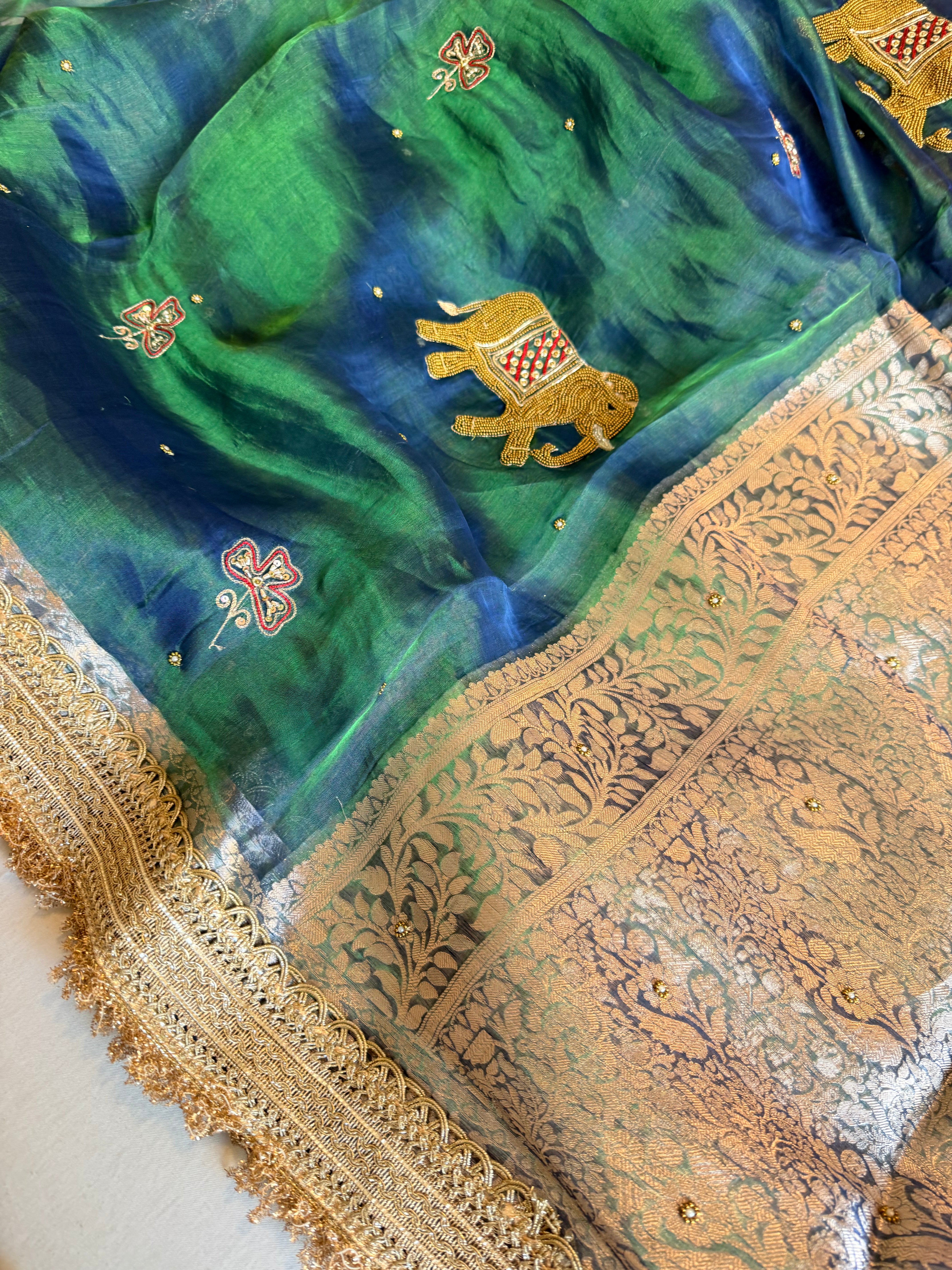 Elephant motif peacock blue dhup chao effect tissue silk hand embroidered saree