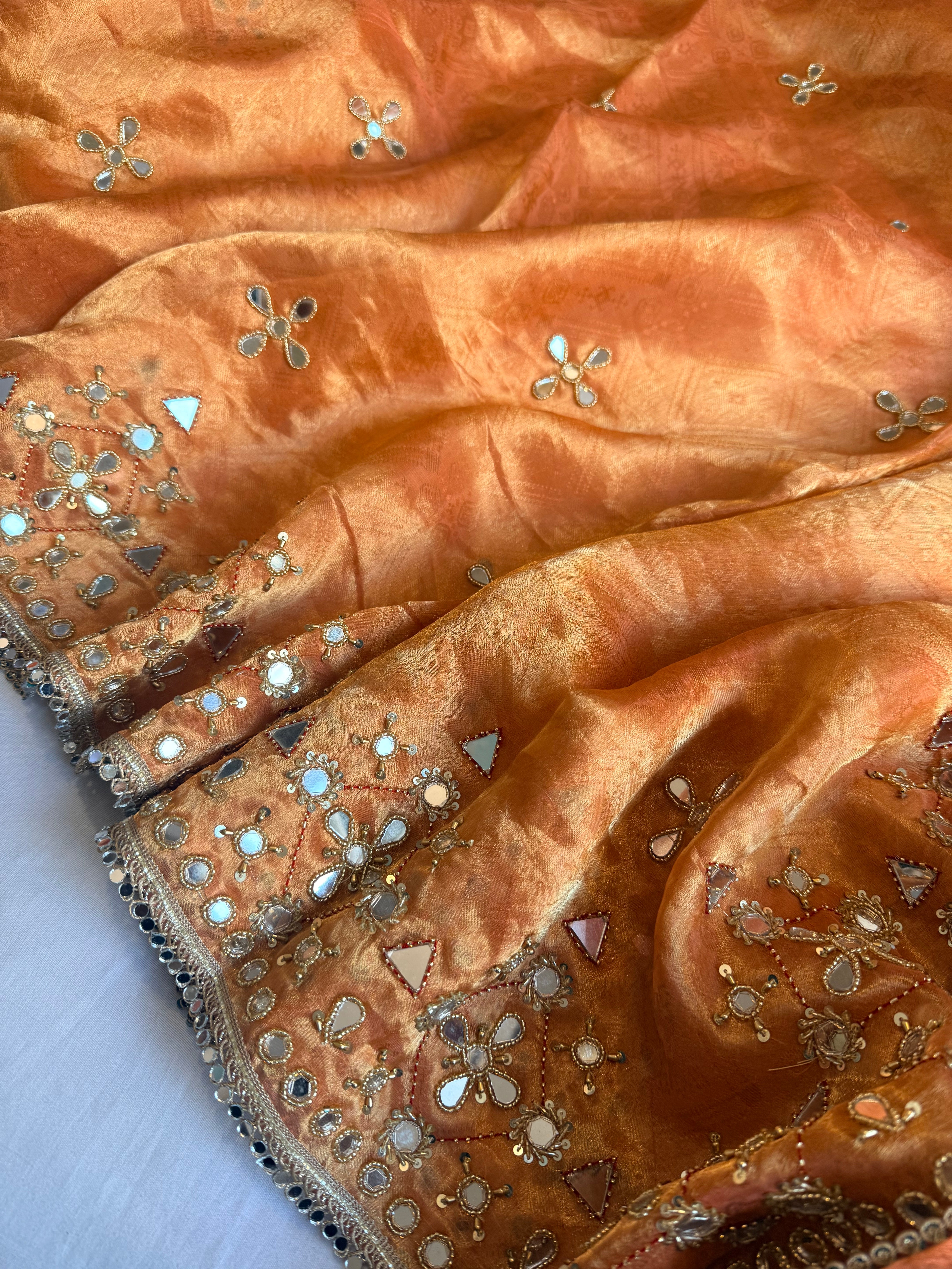 Dhup chao effect kesari orange tanchui tissue silk mirrorwork hand embroidered kadhwa saree